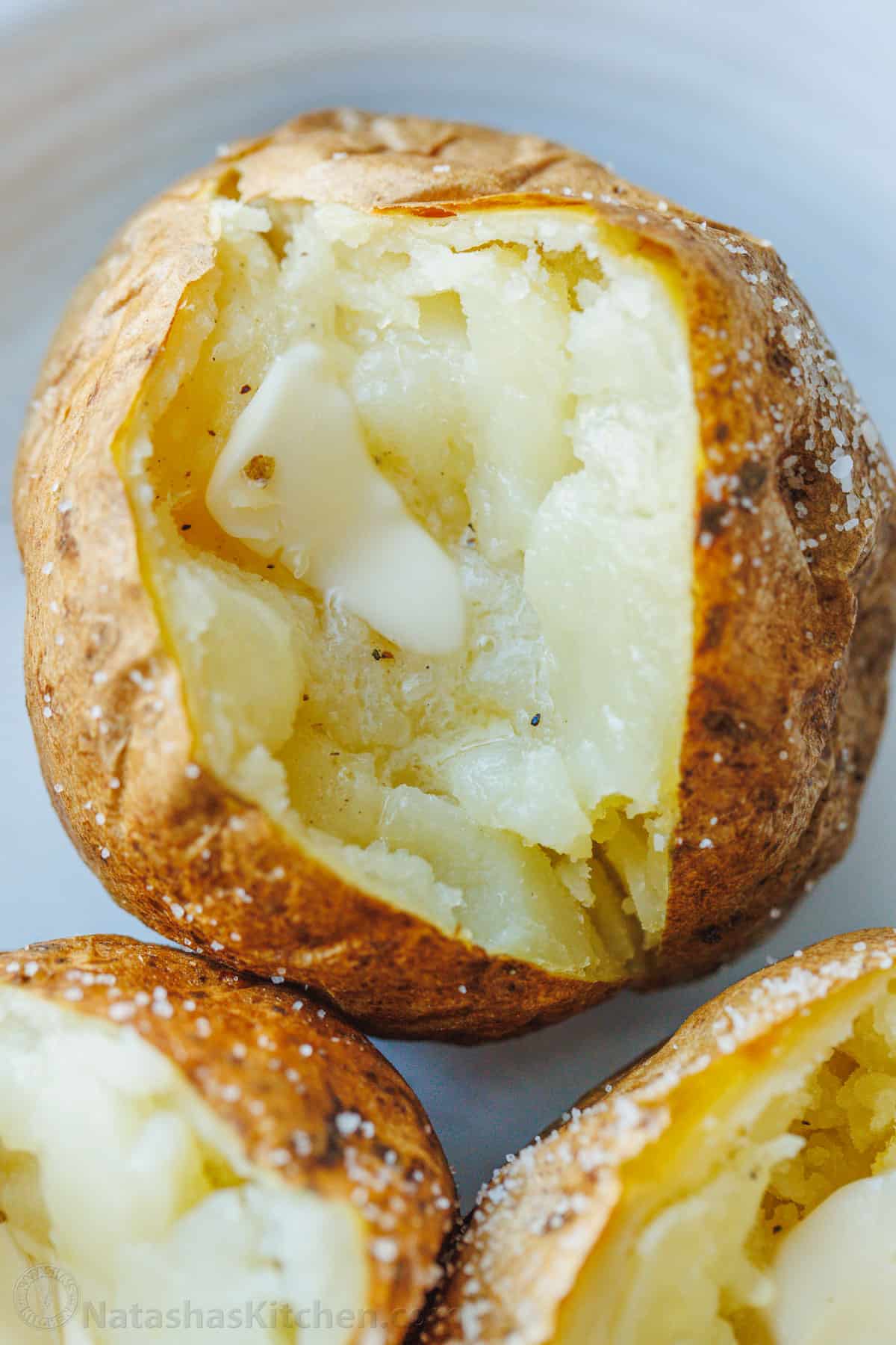 A baked potato sliced open to reveal the fluffy insides.