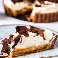 A close-up of a Banoffee pie slice on a blue plate.