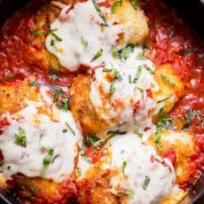 Stuffed Chicken Parmesan in a pan with marinara sauce and cheese topping