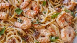 Tuscan Shrimp Pasta with sun-dried tomatoes in a stainless steel pan